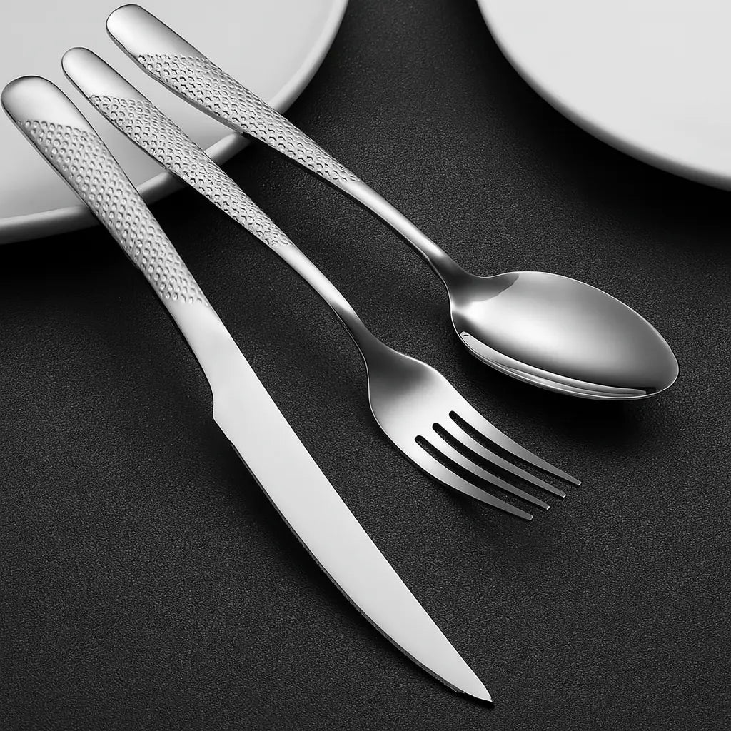 Faqueiro inox 24 peças com cabo texturizado, dispostos sobre prato branco em mesa escura sofisticada