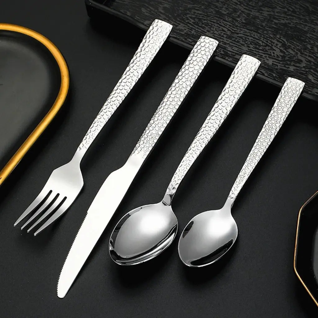 Conjunto de talheres prateados com design estriado, posicionado ao lado de xícara elegante – perfeita harmonia para servir com estilo.